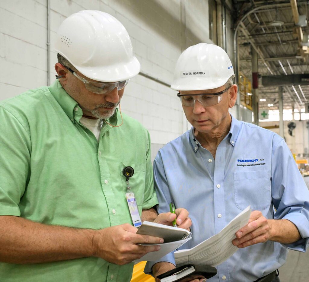 Workers in factory looking over notes