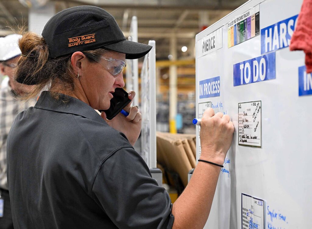 Worker making to-do notes on whiteboard